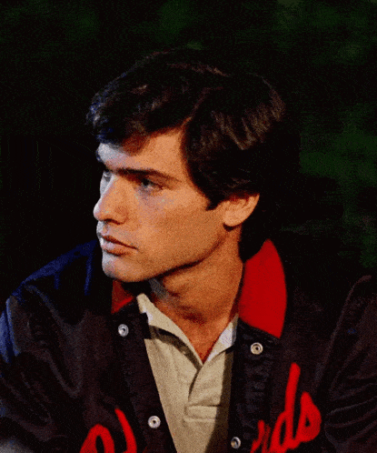 a man wearing a jacket with reds on it