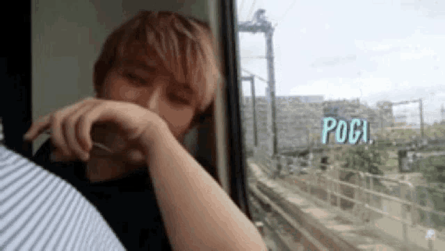 a man is sitting in a train looking out the window .