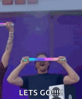 a man is holding a light stick in front of his face and says lets go !!!