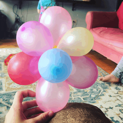 a person is holding a bunch of pink and blue balloons in their hands