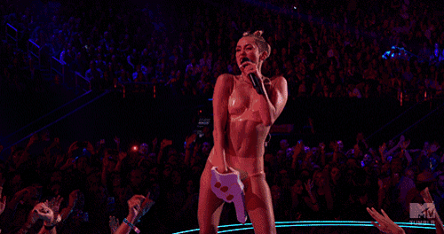 a woman is singing into a microphone on a stage with a mtv logo in the corner