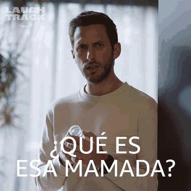 a man holding a baby bottle with the words que es esa mamada on the bottom