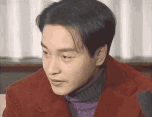 a man in a red jacket and purple turtleneck