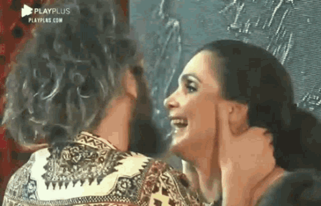 a man and a woman are talking to each other and smiling .