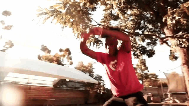a man wearing a red shirt that says ' abercrombie ' on it