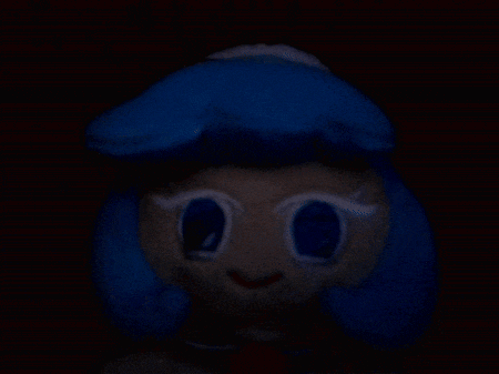 a stuffed animal with blue hair and white eyes in the dark .
