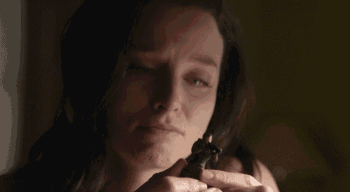 a close up of a woman holding a small object in her hand