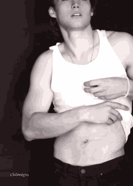 a man in a white tank top has a bracelet on his wrist