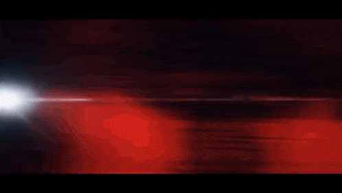 a man is holding a knife in front of a red background .