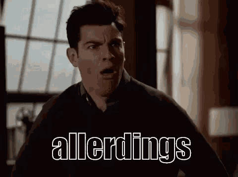 a man with a surprised look on his face is standing in front of a window with the word allerdings written on it .