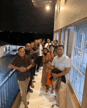 a group of people standing on a balcony looking out the window