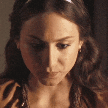 a woman with a headband on her head looks down