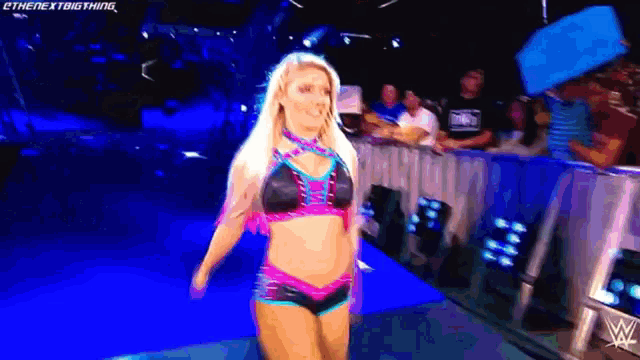 a woman in a bikini is walking on a blue carpet with the words " the next big thing " written on the bottom