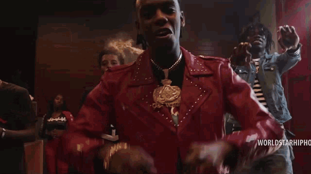 a group of men are standing in front of a red door with the words worldstarhip on the bottom