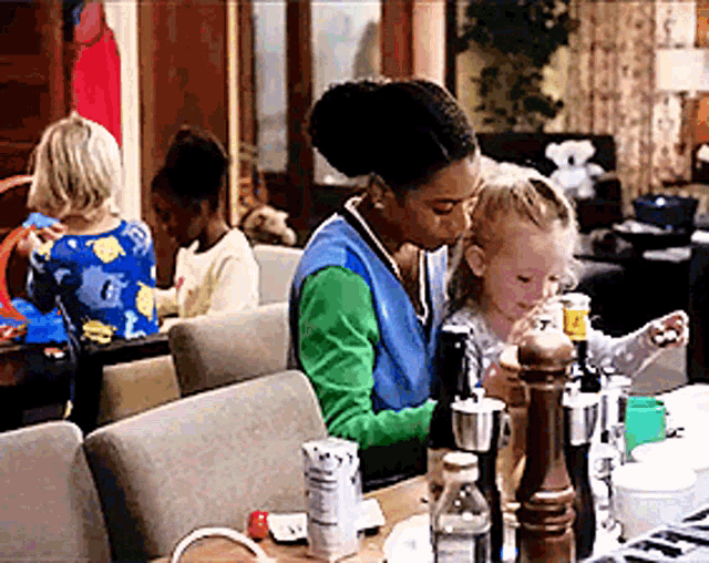 a woman is sitting at a table with a child and a bottle of water