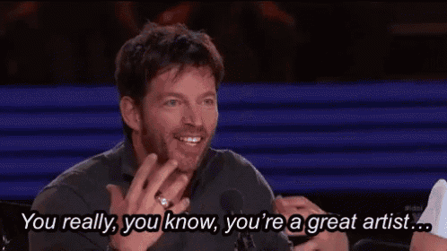 a man is sitting in front of a microphone and saying you really , you know , you 're a great artist