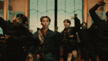 a group of people are dancing in front of a window .