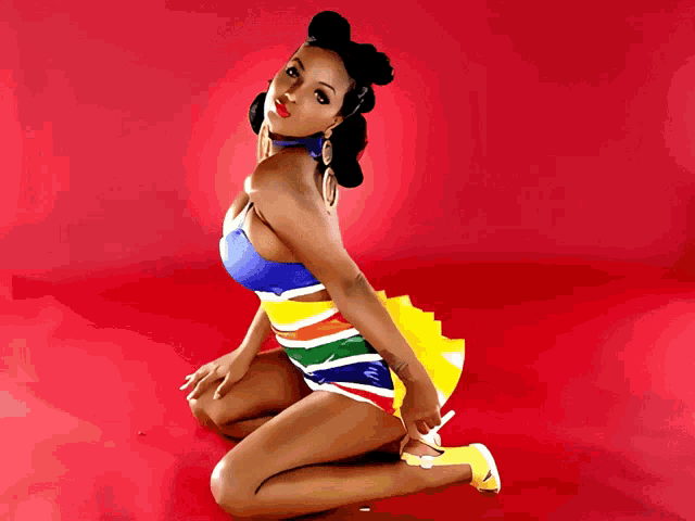 a woman is kneeling on the floor wearing a colorful dress