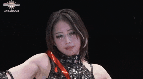 a woman in a black and red outfit with a #stardom logo on the bottom right corner