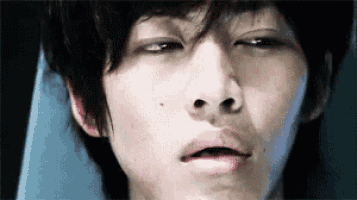 a close up of a young man 's face with his mouth open .