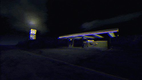 a gas station is lit up at night and has a sign that says ' gp ' on it