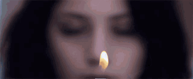 a woman is lighting a candle in her mouth