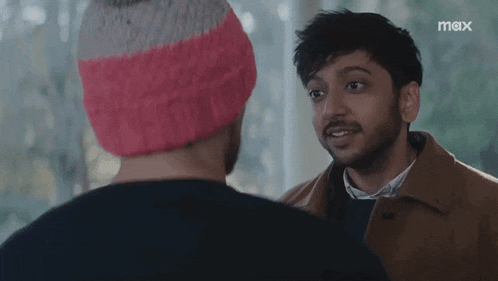 a man in a pink hat says they 're gonna love you while talking to another man