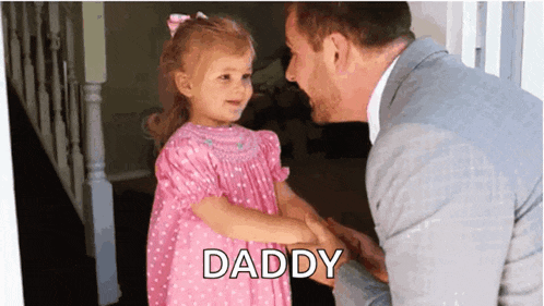 a little girl in a pink dress shakes hands with her father who is wearing a suit and tie