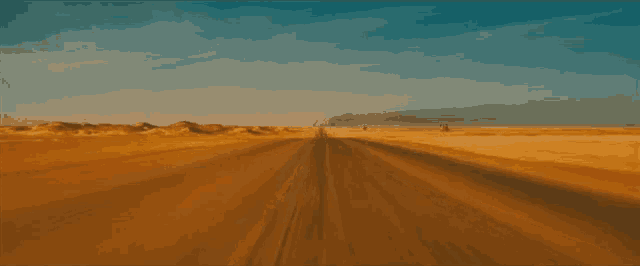 a car is driving down a dirt road through the desert .