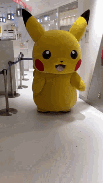 a pikachu mascot is walking down a hallway in a store