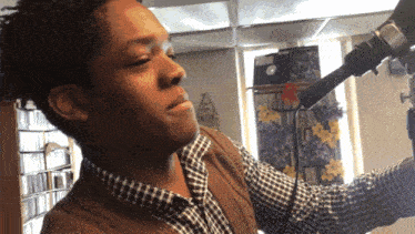 a man in a plaid shirt is holding a camera
