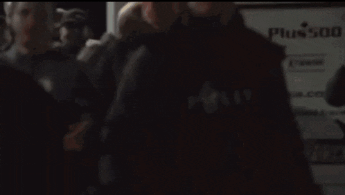 a group of people are gathered in a dark room and one of them has a yellow item with the number 5 on it