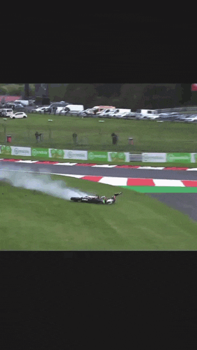 a man riding a motorcycle with smoke coming out of the tire