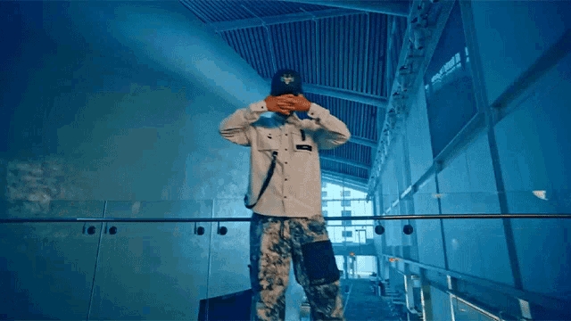 a man wearing a hat with a cross on it is standing on a staircase
