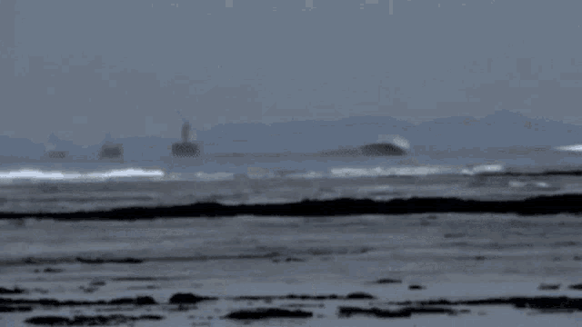 a large wave is breaking on a beach with the word colo in yellow