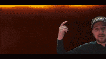 a pixel art of a man standing in front of a red building holding a light .