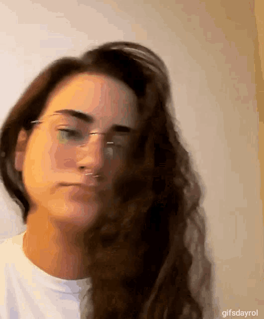 a close up of a woman wearing glasses and a white shirt