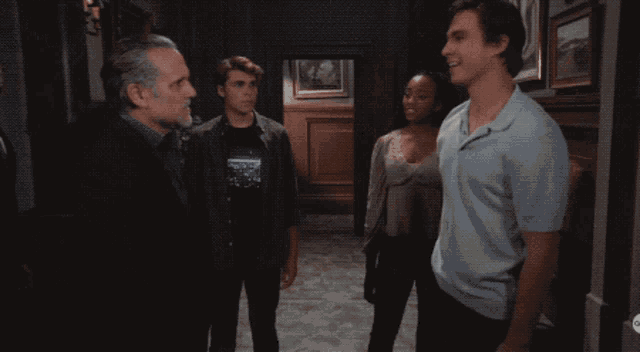 a man in a light blue shirt is smiling while talking to another man