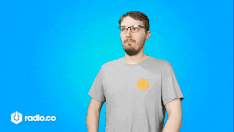 a man wearing glasses and a gray shirt is standing in front of a blue background with radio.co written on it