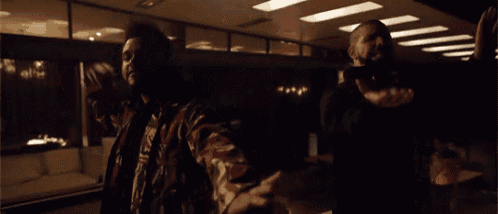 a man in a camo jacket is standing next to another man in a black jacket