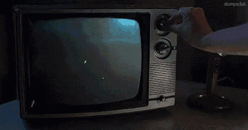 a person is lighting a cigarette in front of a tv that has a fire on it