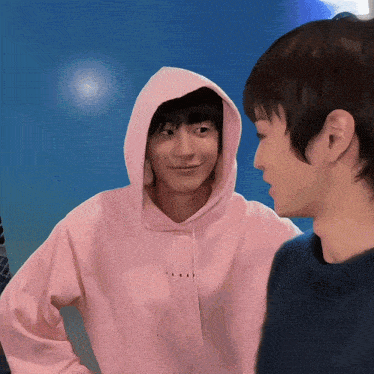 a man wearing a pink hoodie that says " i love you " on it