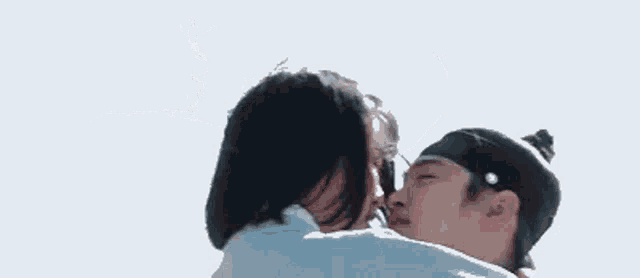 a man is holding a woman in his arms while they kiss .