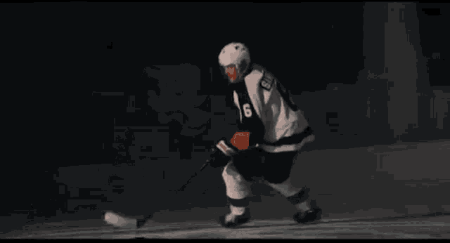 a person in a superhero costume is holding a sword in a dark room .