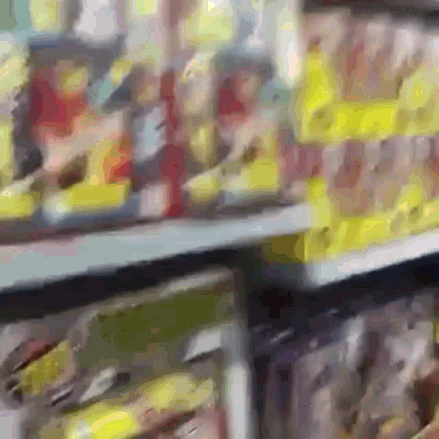 a blurred image of a store aisle with a yellow sign that says ' a ' on it