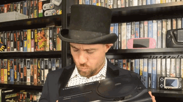 a man wearing a top hat is looking at a video game console