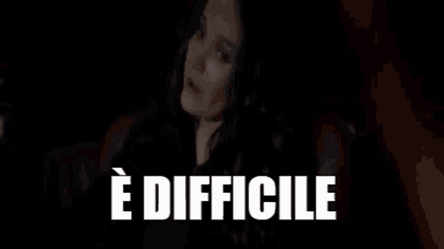 a woman is sitting in a chair in a dark room with the words `` e difficile '' written above her .