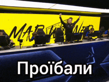 a group of people sitting in front of a yellow sign that says mar