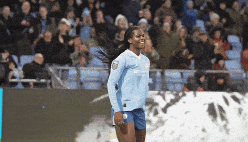 a female soccer player wearing a light blue jersey with etihad on it