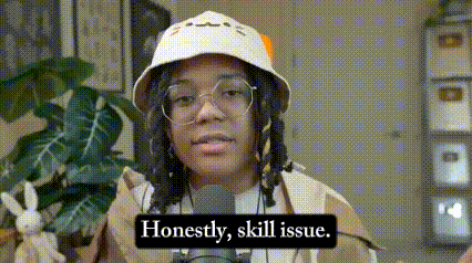 a woman wearing a hat and glasses is talking into a microphone with the words honestly , skill issue .